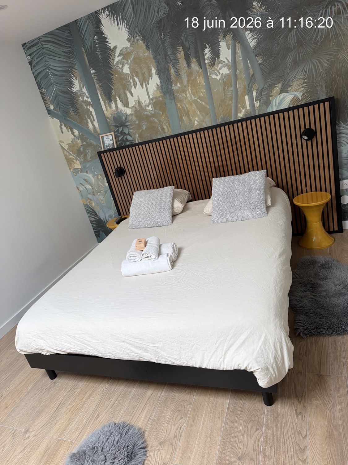 Chambre avec papier peint tropical et tête de lit en tasseaux bois – Ménage Airbnb Strasbourg