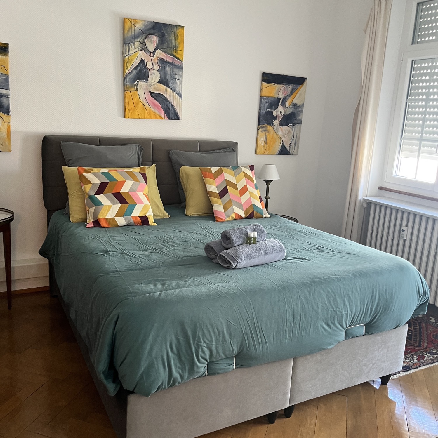 Chambre avec couette vert d'eau, tableaux d'art et coussins colorés – Ménage Airbnb Strasbourg