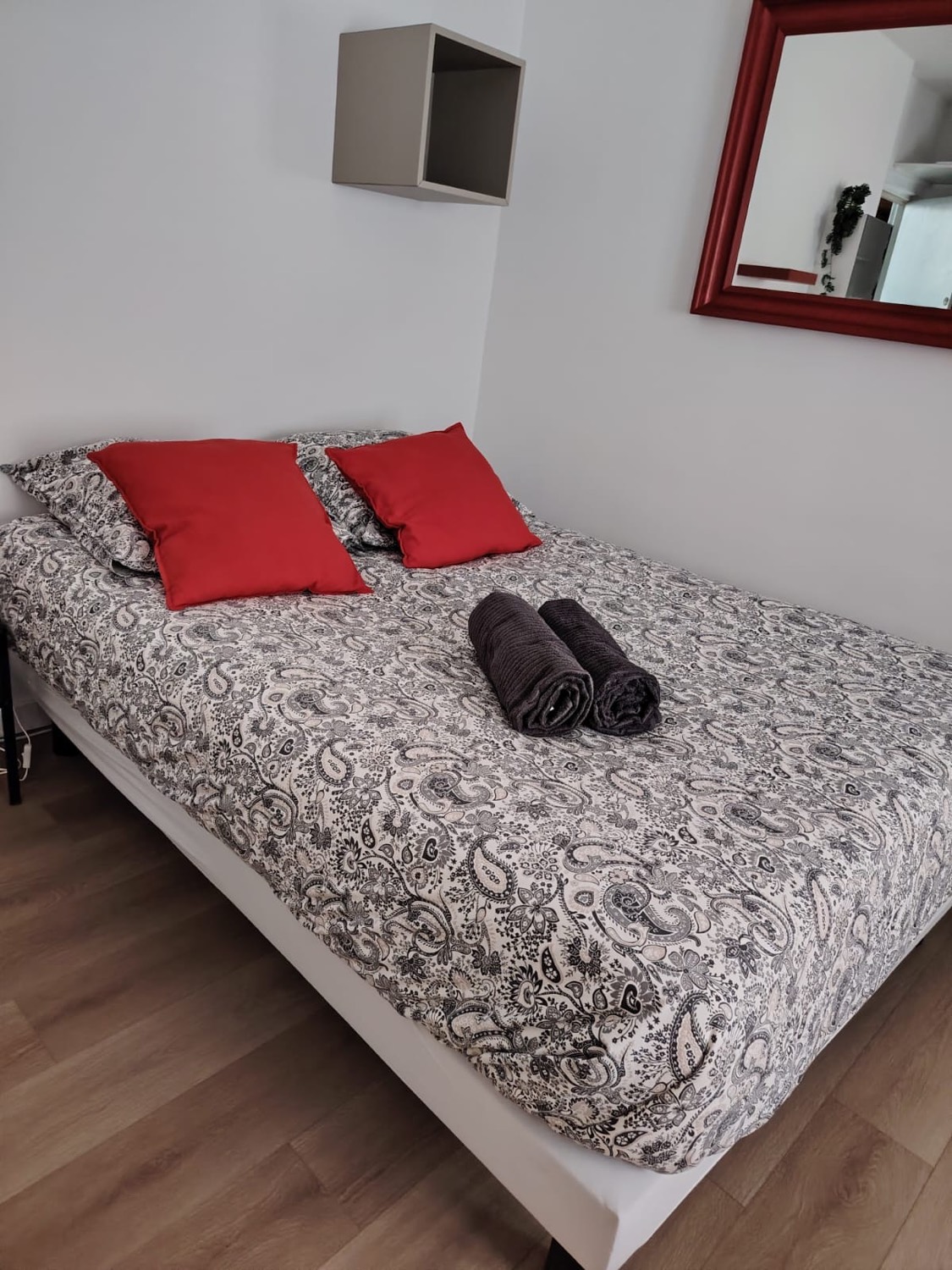 Chambre avec parure paisley et coussins rouges – Ménage Airbnb Strasbourg JG67