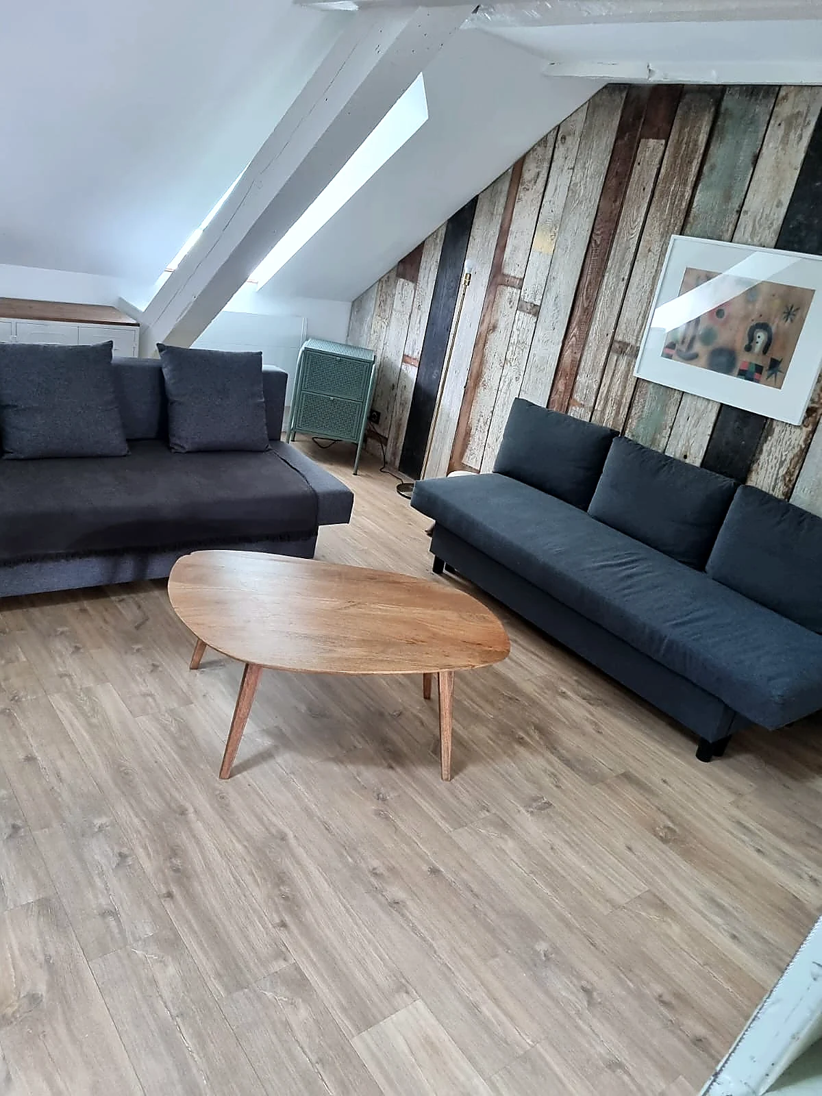 Loft mezzanine canapés anthracite et mur planches – Location courte durée Strasbourg