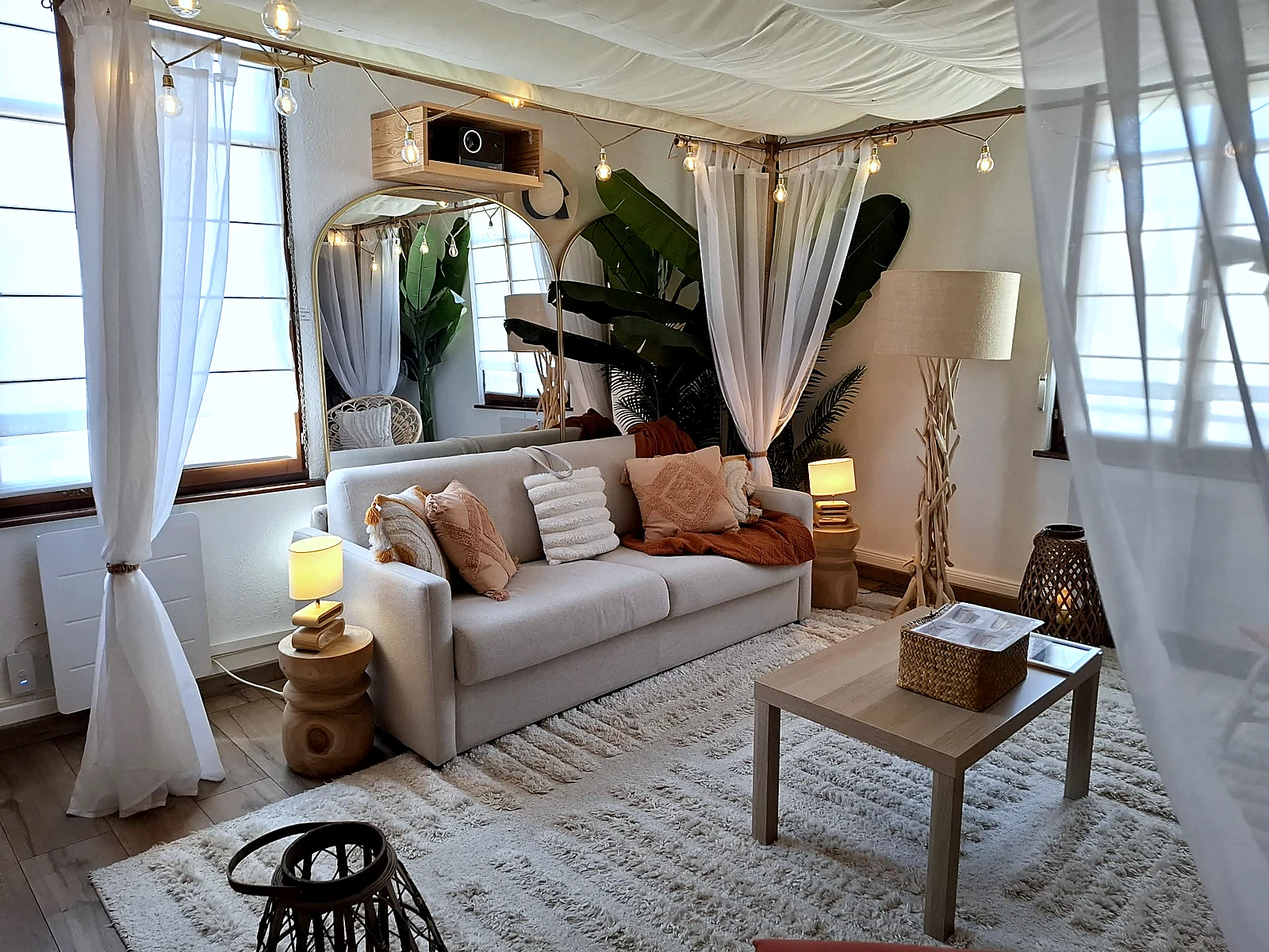 Salon bohème voilages blancs et guirlandes – Logement Airbnb Strasbourg